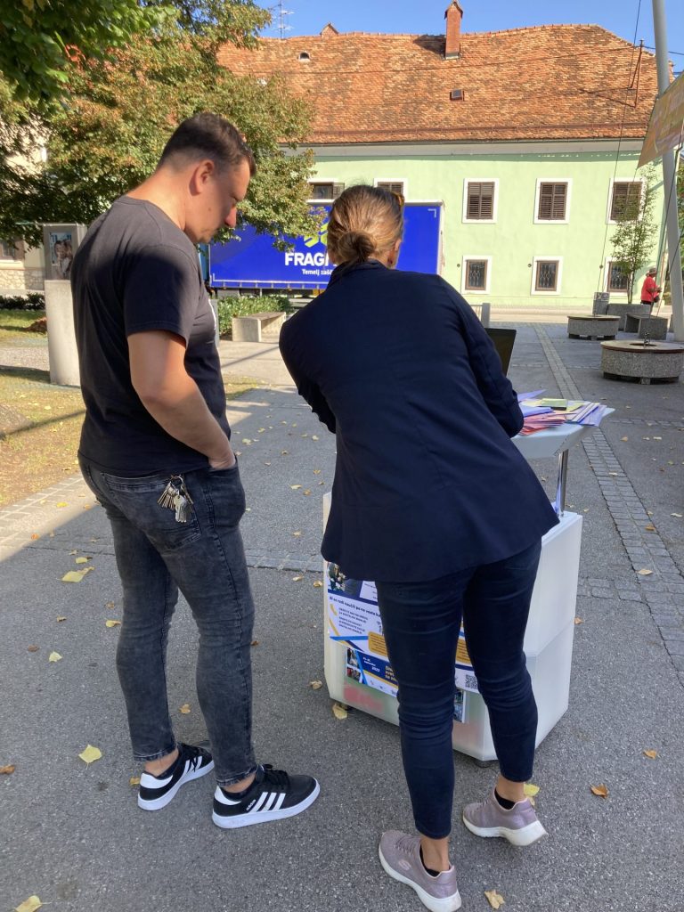 Svetovalka in odrasli ob svetovalni stojnici