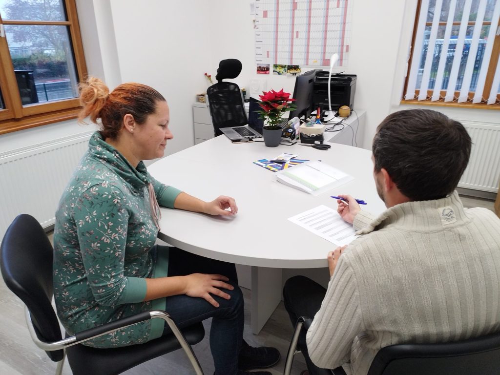 Svetovalka in odrasli med svetovanjem.